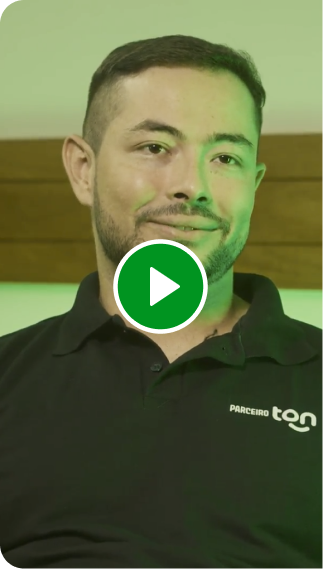 Consultor Renda Extra Ton. Homem com camisa preta sentado em uma poltrona verde.